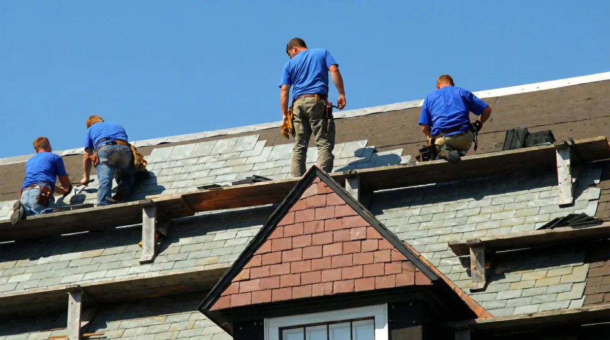 Roof replacement in progress with a team of professional contractors installing new shingles on a residential home in Dover, DE